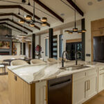 Kitchen island looking towards a living room with large fireplace and high ceilings