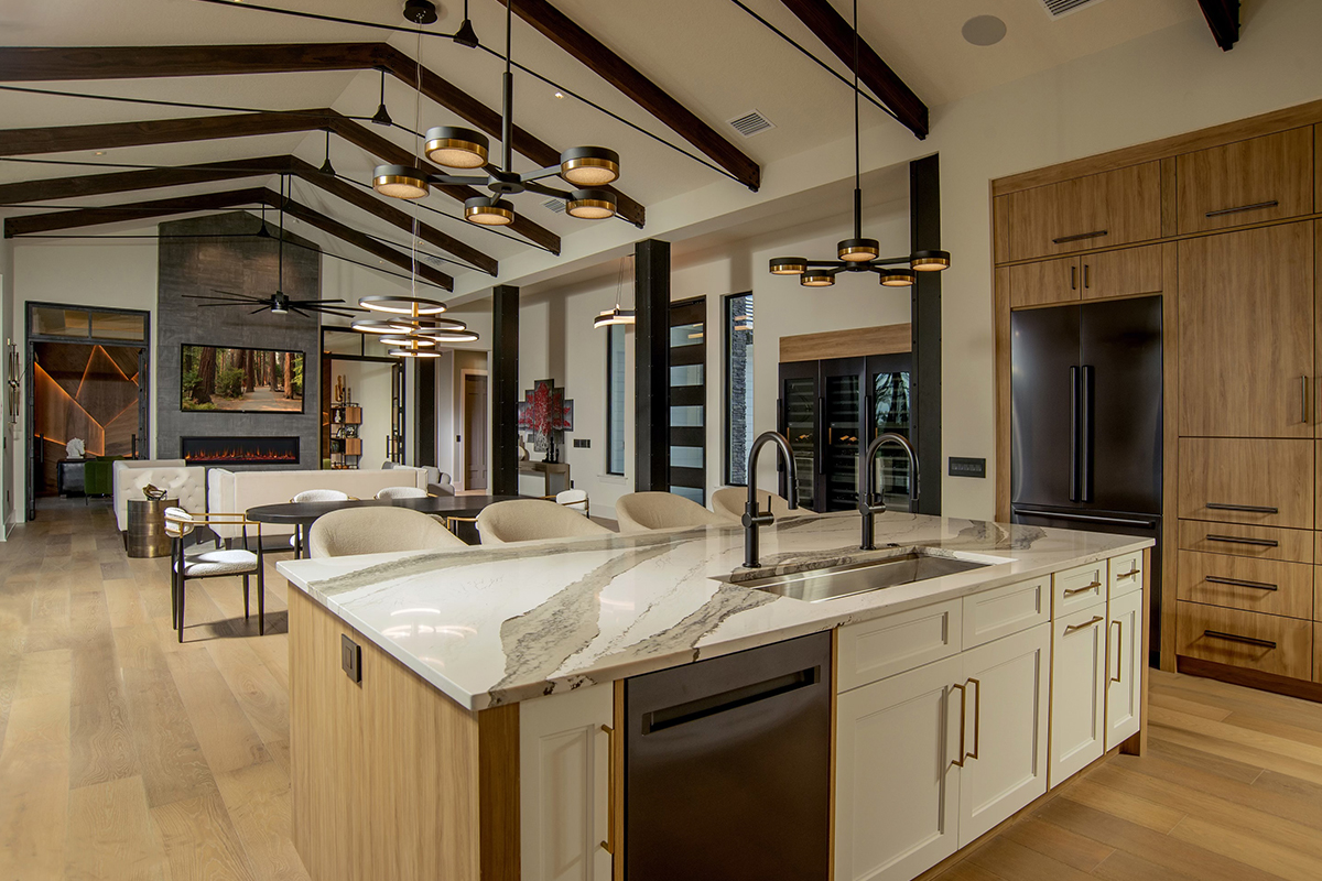 Kitchen island looking towards a living room with large fireplace and high ceilings