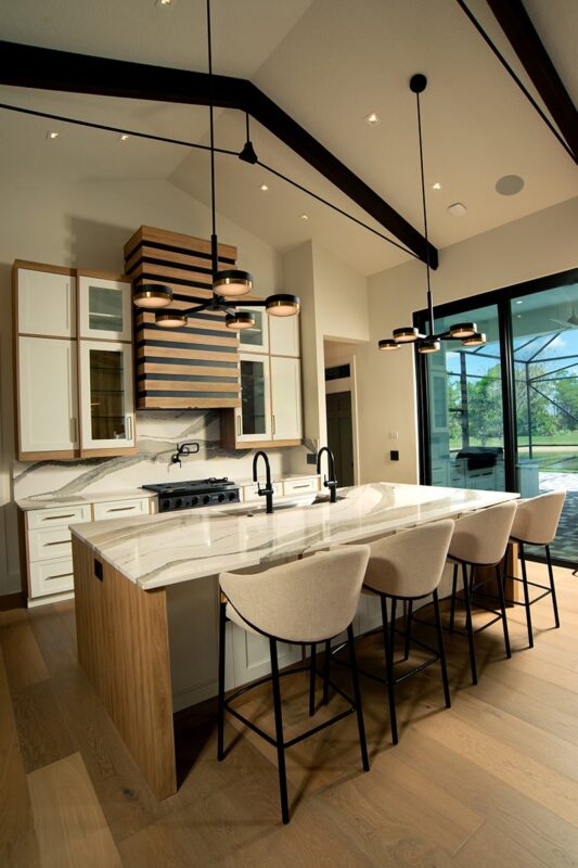 Contemporary and transitional kitchen and island with high ceilings and wood beams.