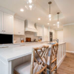 White painted kitchen cabinets with long island.