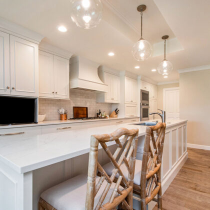 White painted kitchen cabinets with long island.