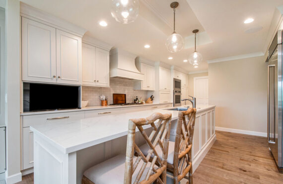 White painted kitchen cabinets with long island.