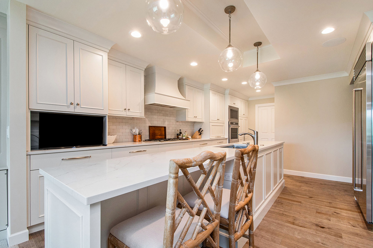 White painted kitchen cabinets with long island.