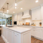 White painted kitchen cabinets with long island.