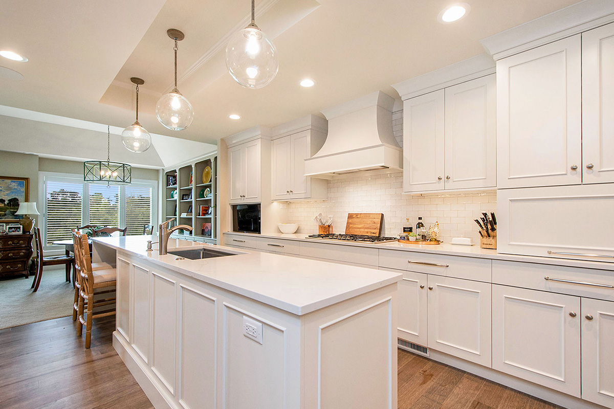 White painted kitchen cabinets with long island.
