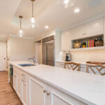 White painted kitchen cabinets with long island.