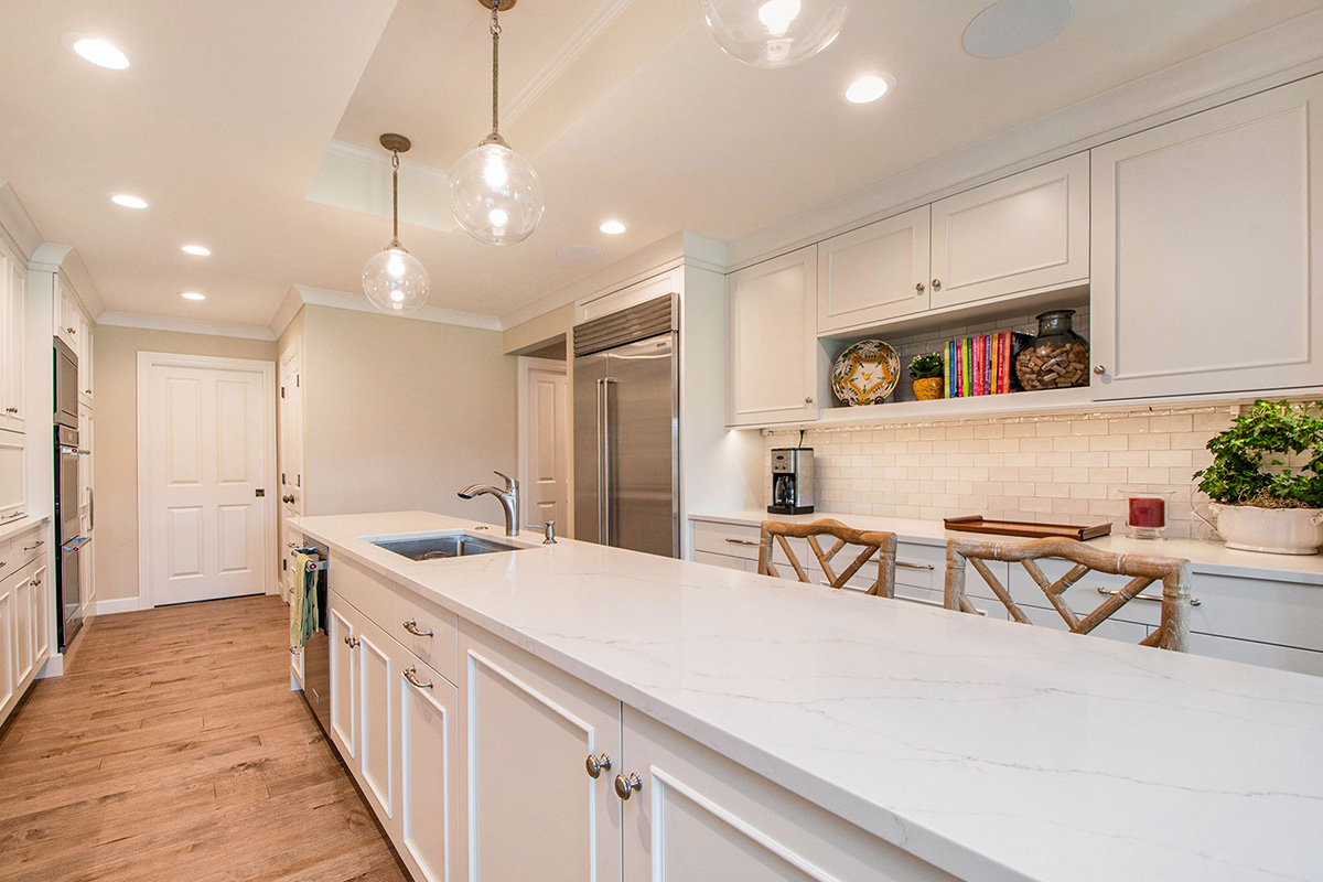 White painted kitchen cabinets with long island.