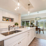 White painted kitchen cabinets with long island.