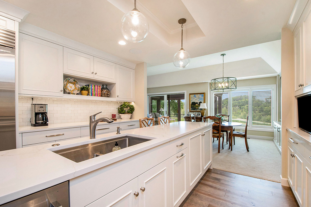 White painted kitchen cabinets with long island.