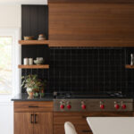Contemporary kitchen in stained walnut with black tile backsplash
