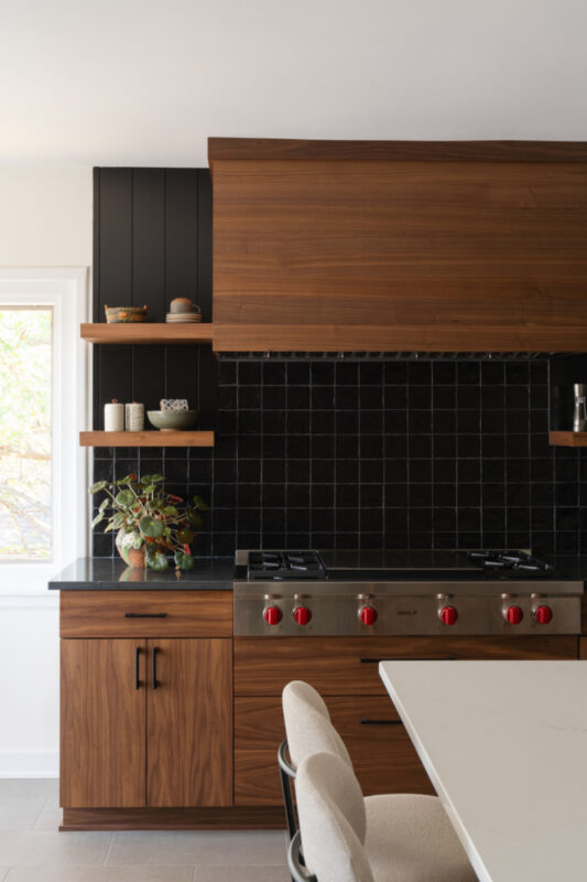 Contemporary kitchen in stained walnut with black tile backsplash