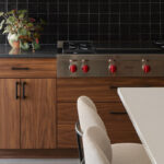 Contemporary kitchen in stained walnut with black tile backsplash