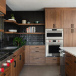 Contemporary kitchen in stained walnut with black tile backsplash