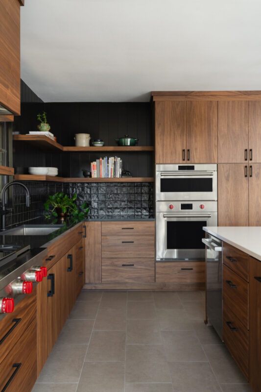 Contemporary kitchen in stained walnut with black tile backsplash