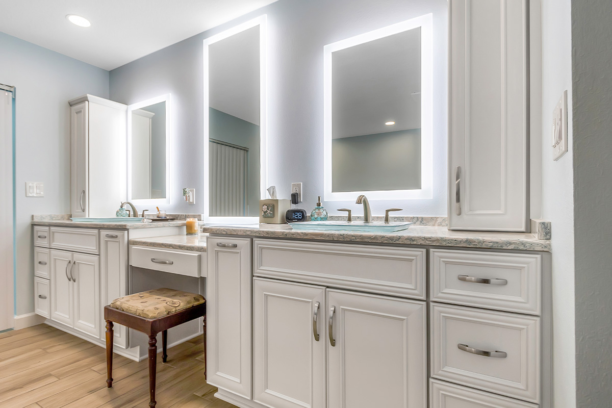 Painted master bath cabinets with backlit mirror and vanity bench