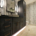 Bathroom vanity cabinets with dark Midnight stain. Bathroom uses "Woods" wall paper.