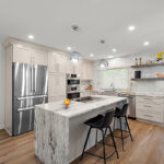 Light Mocha painted kitchen cabinets with an island that includes a beautiful waterfall granite countertop.