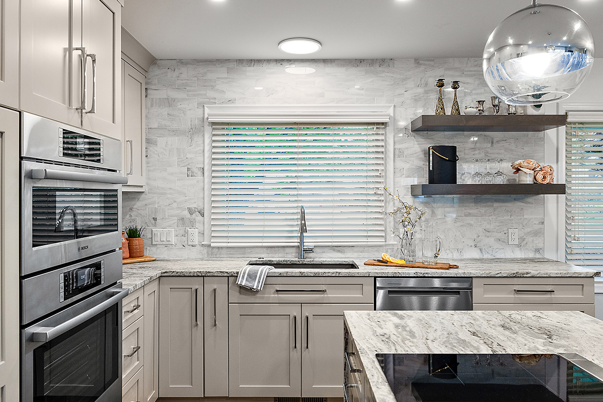 Light Mocha painted kitchen cabinets with an island that includes a beautiful waterfall granite countertop.