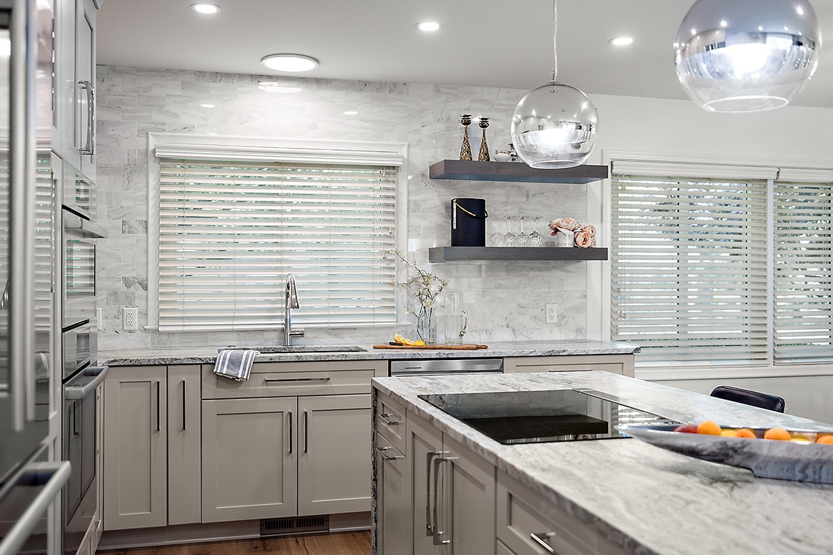 Light Mocha painted kitchen cabinets with an island that includes a beautiful waterfall granite countertop.