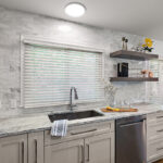 Light Mocha painted kitchen cabinets with an island that includes a beautiful waterfall granite countertop.