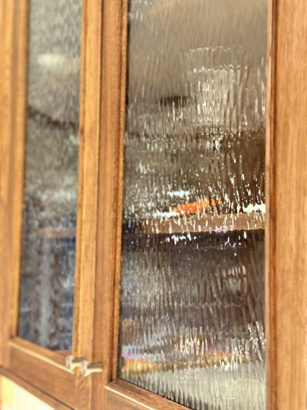 Stained cabinet showing the details of decorative glass in the cabinet door.