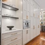 Wall of kitchen storage cabinets painted white