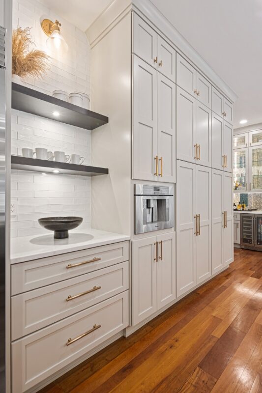 Wall of kitchen storage cabinets painted white