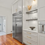 Wall of kitchen storage cabinets painted white