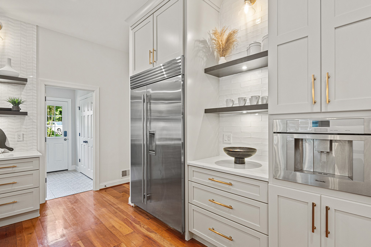Wall of kitchen storage cabinets painted white