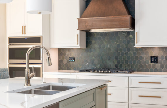 White painted kitchen perimeter with stained wood hood and gray painted island