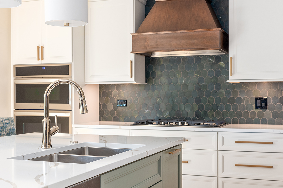 White painted kitchen perimeter with stained wood hood and gray painted island