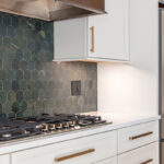 White painted kitchen perimeter with stained wood hood and gray painted island