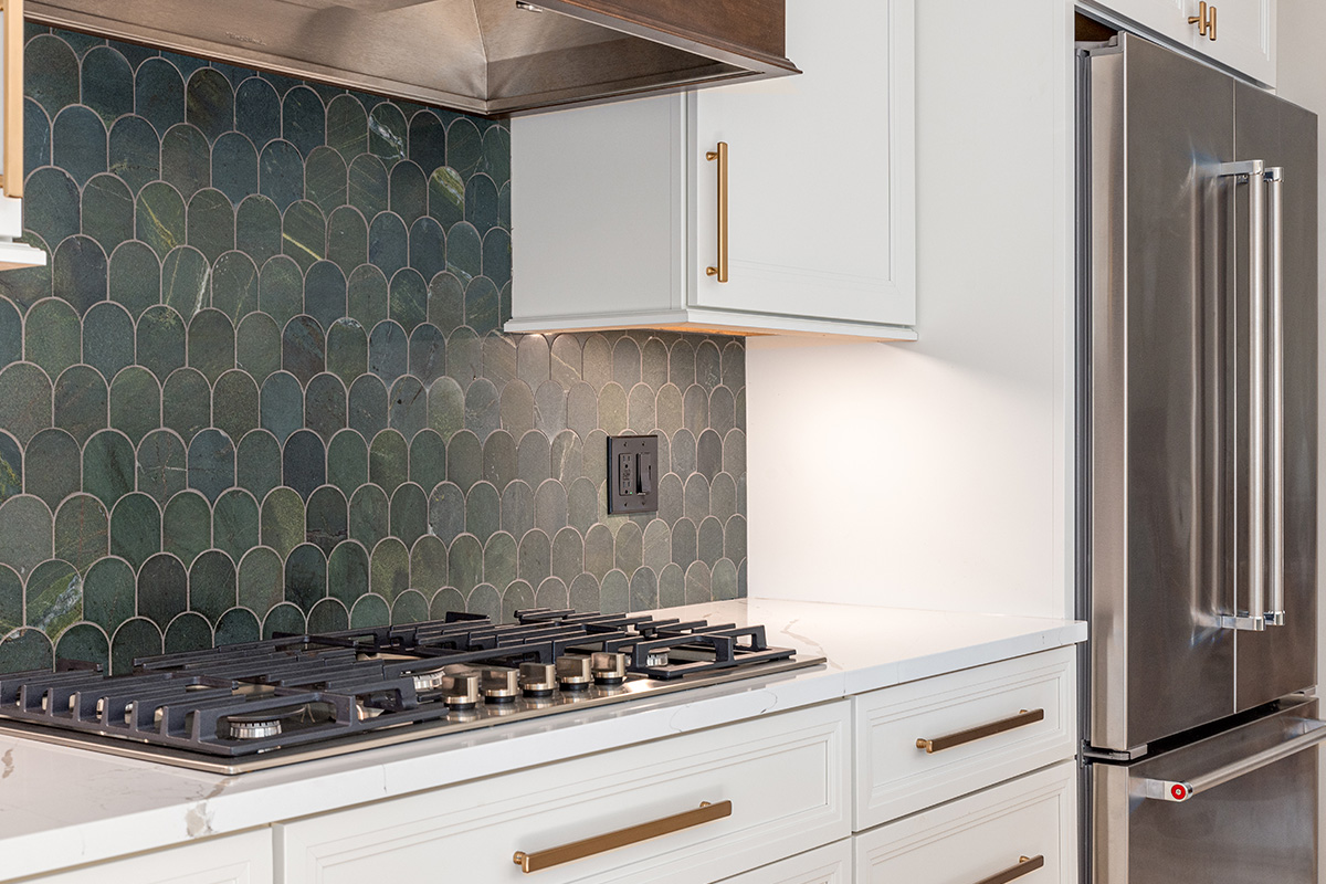 White painted kitchen perimeter with stained wood hood and gray painted island