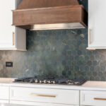 White painted kitchen perimeter with stained wood hood and gray painted island