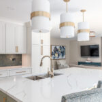 White painted kitchen perimeter with stained wood hood and gray painted island