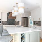 White painted kitchen perimeter with stained wood hood and gray painted island