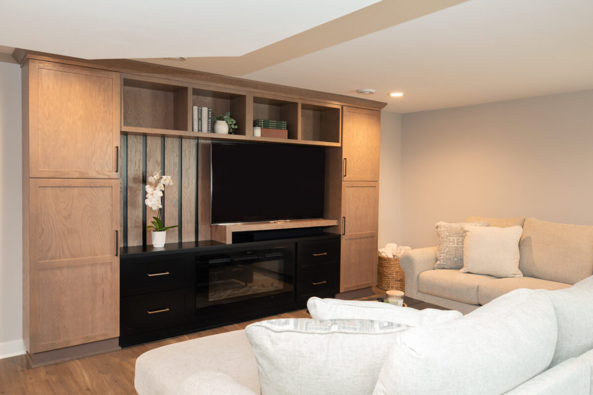 Two toned entertainment center with flat screen tv and white couch