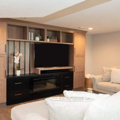 Two toned entertainment center with flat screen tv and white couch
