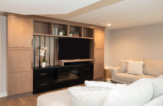Two toned entertainment center with flat screen tv and white couch