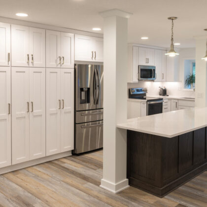 kitchen with white painted perimeter cabinets and reddish brown stained island