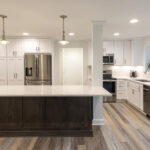 kitchen with white painted perimeter cabinets and reddish brown stained island