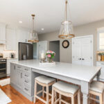 Painted kitchen cabinets. White perimeter and gray island.