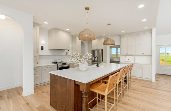 White painted kitchen cabinets and stained island.