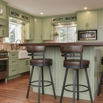 Painted kitchen cabinets in a mint green color. Shows island with stools.