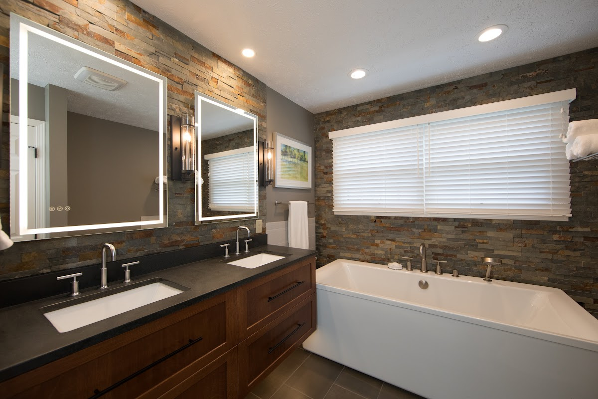Floating vanity finished in Autumn stain near a large white tub.