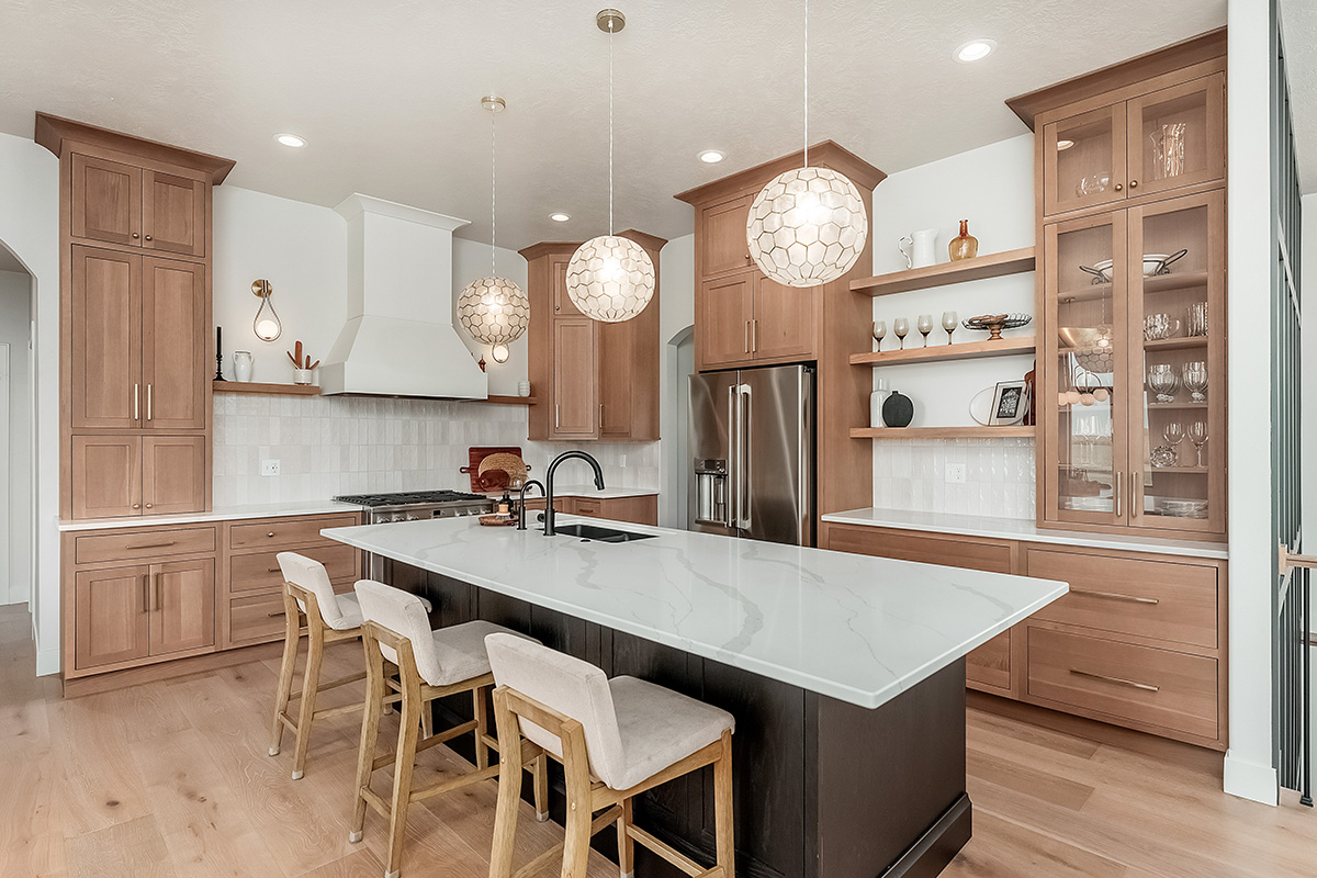 Light brown-stained kitchen cabinets with a white painted wood hood and dark stained island cabinets