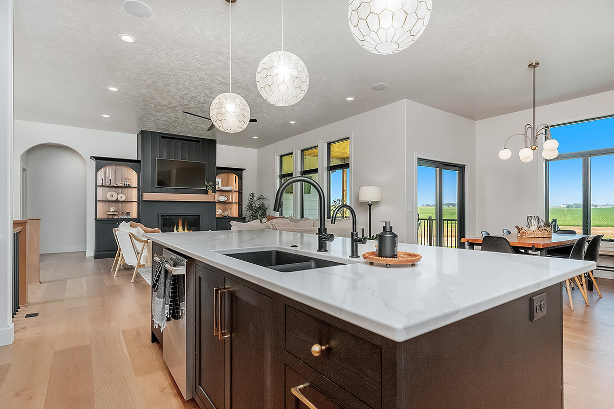 Dark stained island cabinets with living room and fireplace shown in the distance