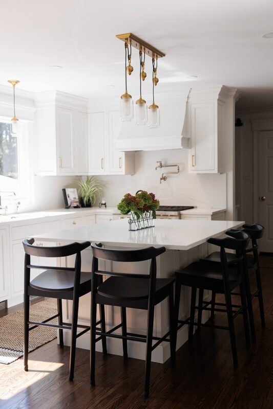 White kitchen with black island seating.