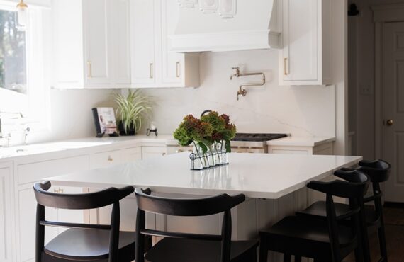 White kitchen with black island seating.