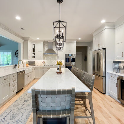 Painted white kitchen perimeter cabinets with brown stained island.
